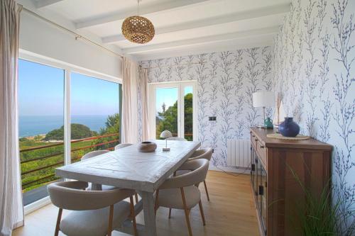 a dining room with a table and chairs and a window at Marina House in Pechón