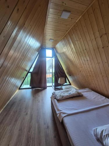 a bed in a room with a wooden ceiling at Eco Villa, A frame with barbecue zone and pool in Yerevan