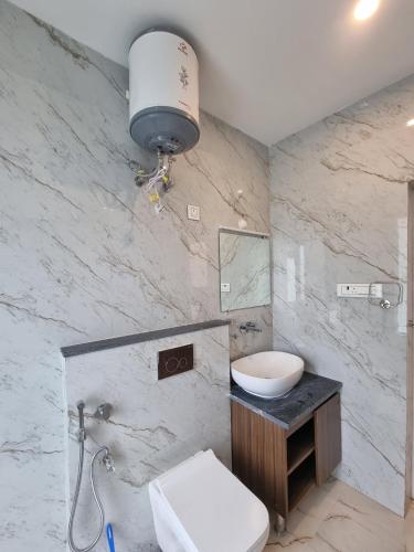 a bathroom with a toilet and a sink and a mirror at Hotel Luxe Vista Dalhousie in Dalhousie