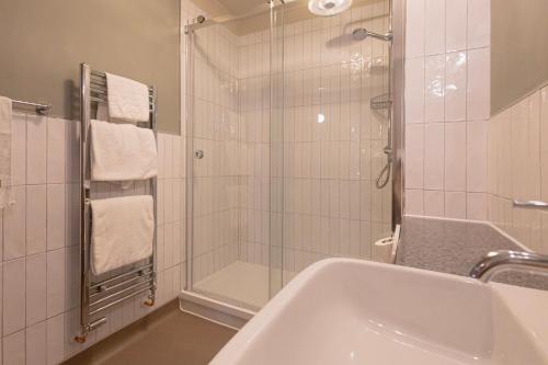 a bathroom with a shower and a sink and a tub at The Red Lion Hawkshaw in Bury