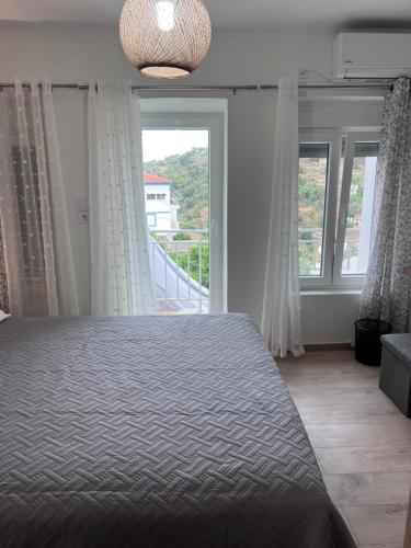 a bedroom with a bed and a large window at Aegean View House Plomari in Plomari
