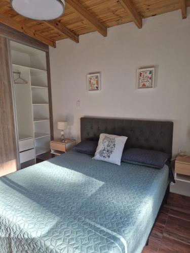 a bedroom with a large bed with a blue comforter at Casa Cris Pinamar in Pinamar