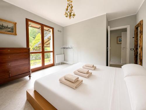 a bedroom with a large white bed with towels on it at Villa dei Mumi in Luino