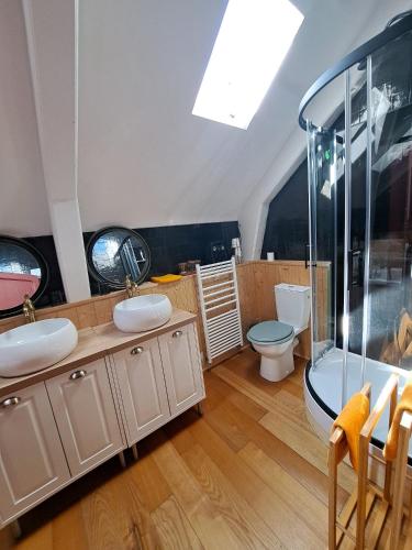 a bathroom with two sinks and a shower and a toilet at La Ferme de Tréfumel in Tréfumel