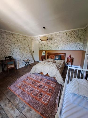 a bedroom with a bed and a rug on the floor at La Ferme de Tréfumel in Tréfumel