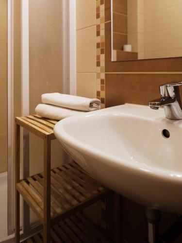 a bathroom with a sink and a mirror and towels at Vyhliadka Galfy in Starý Smokovec