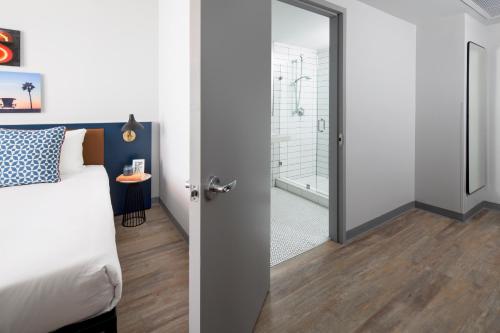a bedroom with a bed and a bathroom with a shower at Hotel Rendale Miami Beach in Miami Beach