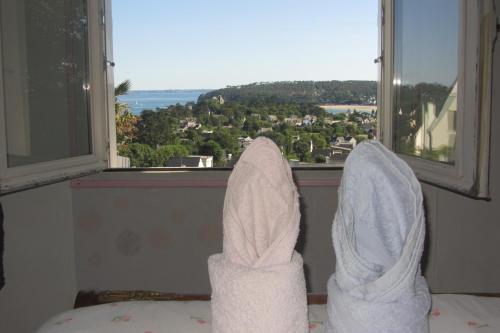 a pair of white shoes looking out a window at Maison avec vue sur Morgat in Crozon
