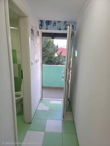 a bathroom with a door open to a bathroom with a toilet at Deskom Zelena Vila in Veliko Gradište
