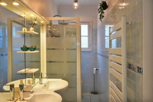 a bathroom with a sink and a mirror and a shower at Ferienhaus Rafalenadjan, ideal für Familien, eigener Pool, schöne Terrasse, eigener Parkplatz by Riviera Homelife Management in Saint-Raphaël