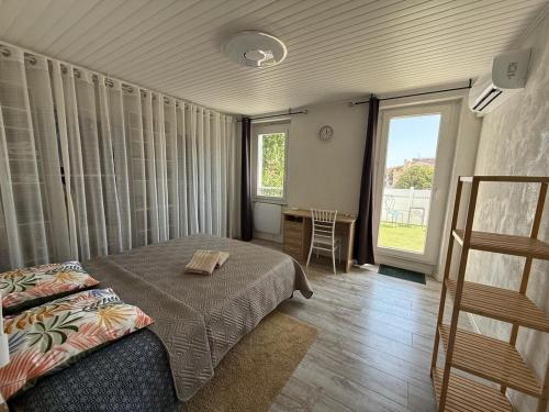 a bedroom with a bed and a table and a window at La Maison Blanche in Perpignan