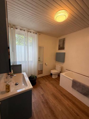 a bathroom with a tub and a sink and a toilet at La Maison Blanche in Perpignan