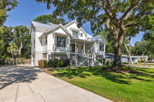 a white house with a tree and a basketball hoop at 26th Ave 23 in Isle of Palms