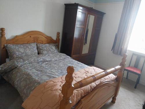 a bedroom with a wooden bed and a wooden dresser at Fortedward Farm House in Thurles