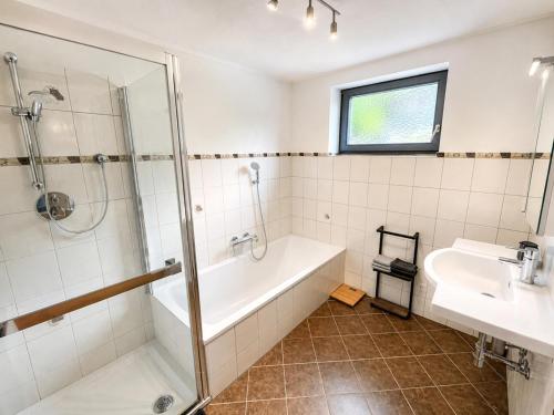a bathroom with a shower and a tub and a sink at Haus am Stein in Stuhlfelden