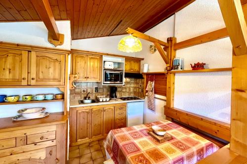 a kitchen with wooden cabinets and a stove top oven at Les Toits des Cateaux in Combloux