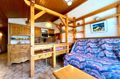 a living room with a couch and a kitchen at Les Toits des Cateaux in Combloux