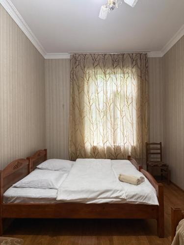 a bedroom with a bed and a window with a curtain at Konstanta in Lentekhi