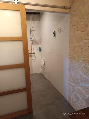 a shower with a glass door in a bathroom at Château Latour - B&B, Pool, Parking, Dinner pre-bookable in Fours