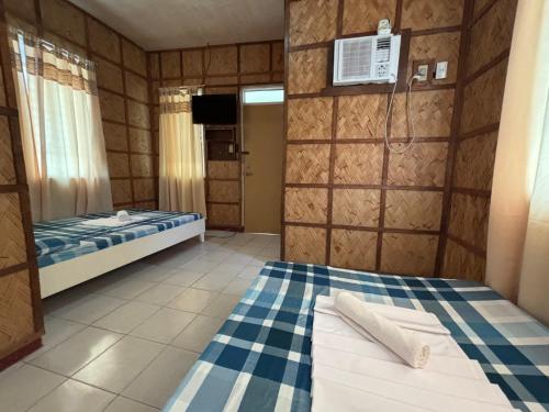a small room with a bed and a tv at Medelaine's Beach Resort in Puerto Galera