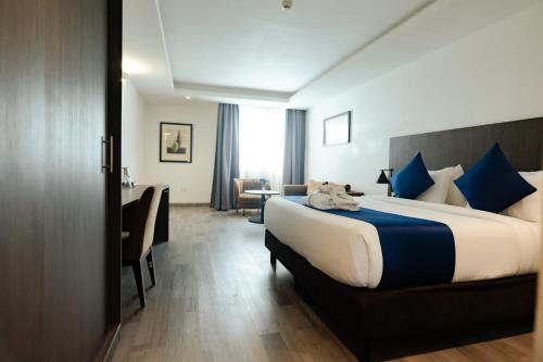 a hotel room with a large bed and a desk at Alisa Hotel North Ridge in Accra