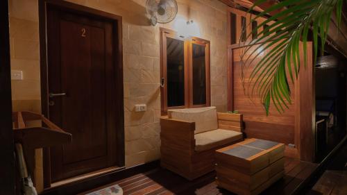 a room with a chair next to a door at Mango Garden in Gili Islands