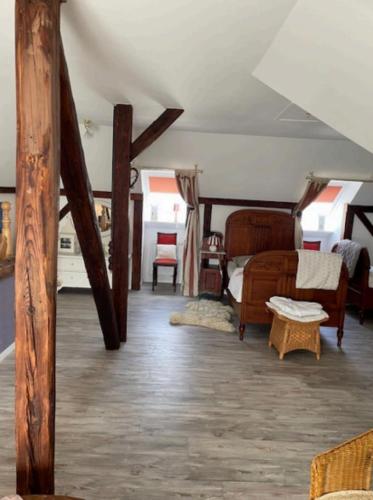 a room with a bedroom with a bed and chairs at Ferienwohnung Lykos in Süderbrarup