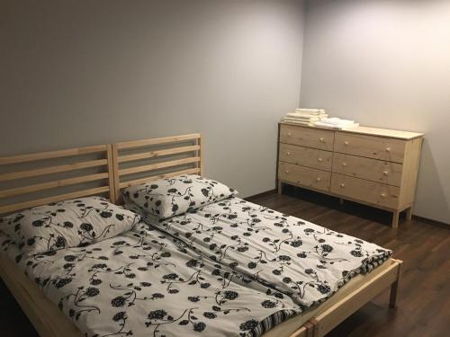 a bed with a black and white comforter and a dresser at Apartamenty Nad Potoczkiem in Ustroń