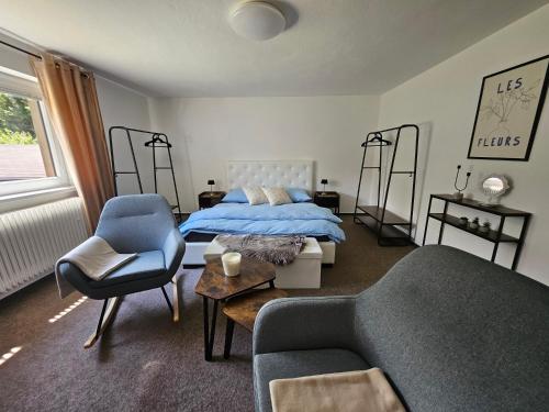 a bedroom with a bed and a couch and a chair at Privát ANAMON Gaštanová in Kežmarok