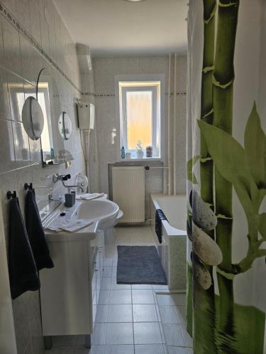 a white bathroom with a sink and a tub at Privát ANAMON Gaštanová in Kežmarok