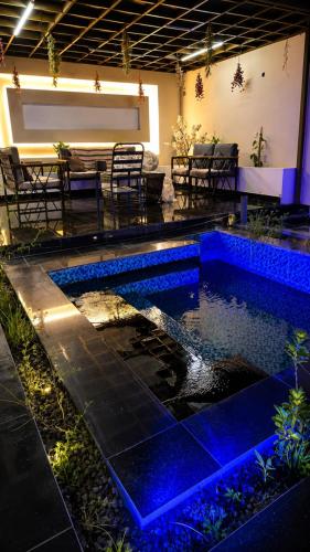a pool in a room with a table and chairs at شالية ويفز ينبع - Waves Chalet Yanbu in Yanbu