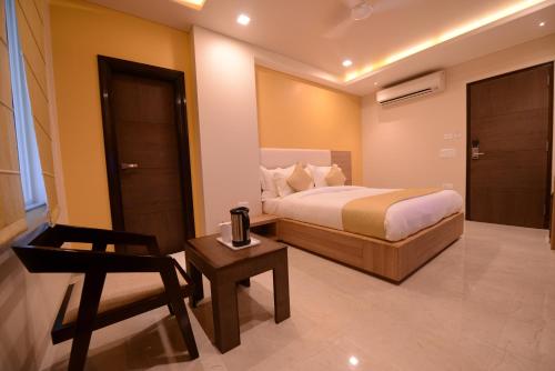 a bedroom with a bed and a chair and a table at Silver Pride Boutique Hotel in Jaipur