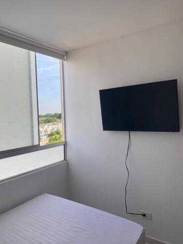 a bedroom with a bed and a flat screen tv on the wall at Valparaiso in Valledupar