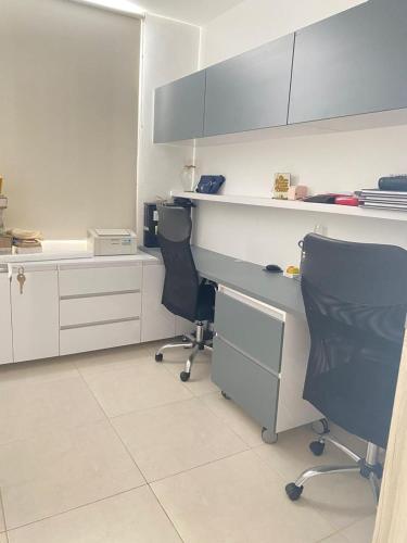 a kitchen with two chairs and a desk and cabinets at Valparaiso in Valledupar