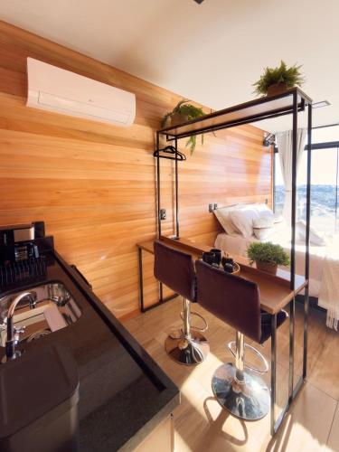 a room with a desk and a bed at Encantos de Altitude Cabanas e Studio Container in São Joaquim
