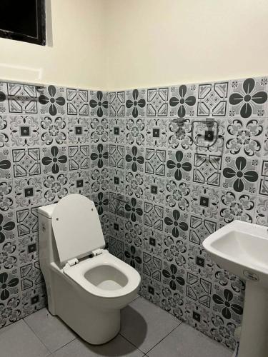 a bathroom with a toilet and a sink at Casa de Lilong in Mahinog