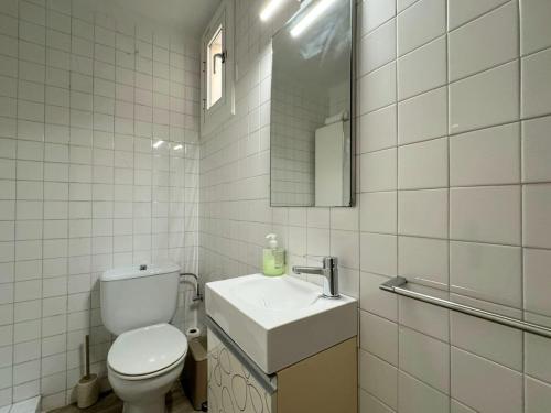 a bathroom with a toilet and a sink and a mirror at HomeHolidaysRentals Miracel - Costa Barcelona in Malgrat de Mar