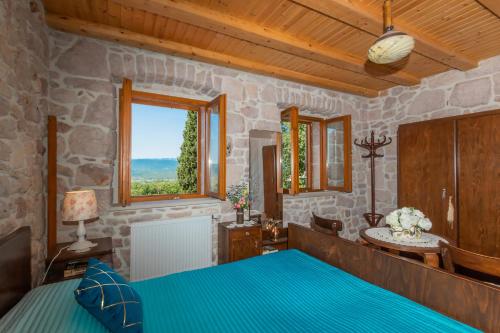 a bedroom with a blue bed and a window at Luxury Resort Dobri Dida in Imotski