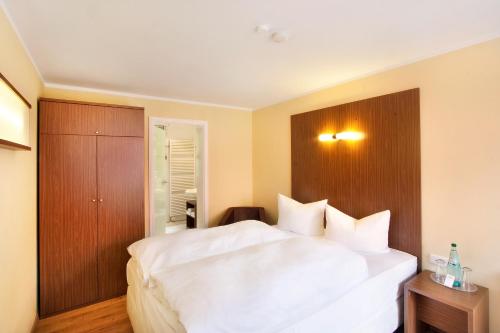 a bedroom with a large white bed and wooden cabinets at Springbach-Mühle Belzig in Bad Belzig