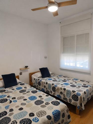 two beds sitting next to each other in a room at Apartamento Altafulla in Altafulla