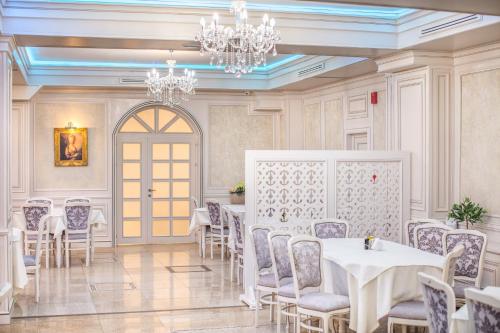 a dining room with tables and chairs and a chandelier at Hotel Eden in Iaşi