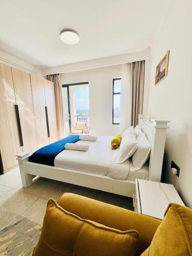 a large bed in a room with a couch at Nyvin Homes at The Loftel in Ruaka