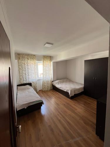 an empty room with two beds and a window at Келечек in Cholpon-Ata