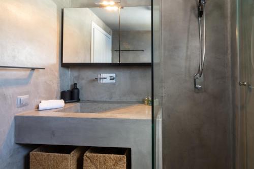 a bathroom with a sink and a mirror at The Rock View Apartment in Mikonos