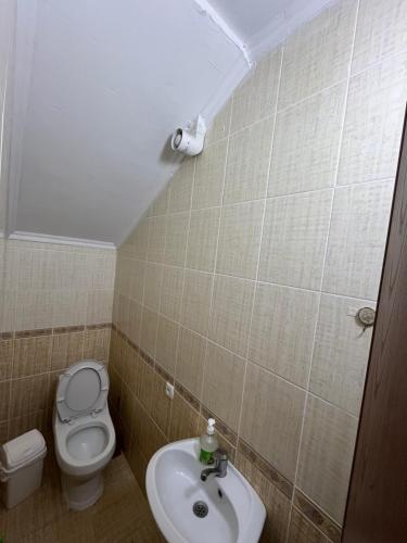 a small bathroom with a toilet and a sink at Келечек in Cholpon-Ata