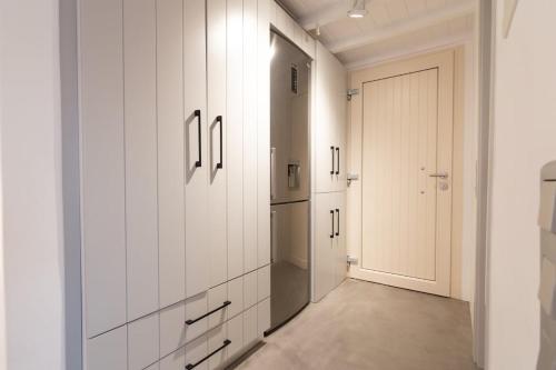 a kitchen with white cabinets and a door at The Rock View Apartment in Mikonos