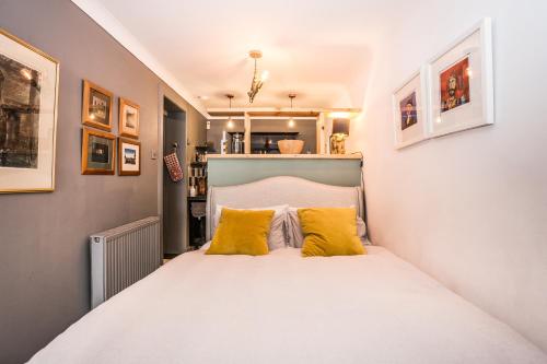 a small bedroom with a bed with yellow pillows at Daiches Braes Brunstane Portobello in Edinburgh