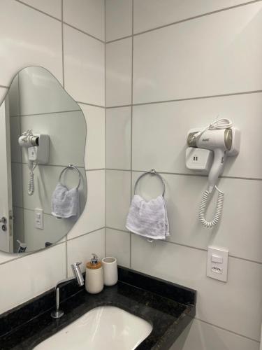 a bathroom with a sink and a phone and a mirror at Apartamento Max Derby Boulevard in Recife