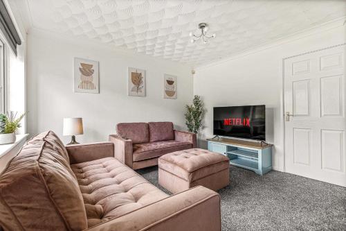 a living room with a couch and a tv at Contractor Base Parking 4 Beds Fast Wi-Fi in Bolton upon Dearne