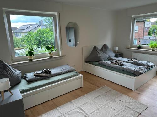 a living room with two beds and two windows at Green View - JK Apartments in Datteln